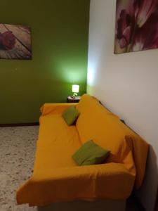 a yellow bed in a green room with a lamp at Casa Alba in Cefalù