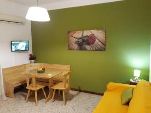 a living room with a table and a green wall at Casa Alba in Cefalù