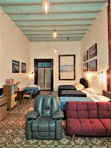 a living room with a bed and a couch and chairs at Suite Vintage in Puebla