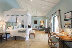 a bedroom with a canopy bed and a desk at Kahanda Kanda in Koggala +37 photos