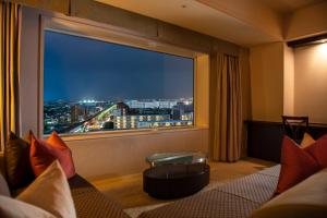 a room with a large window with a view of a city at Urayasu Brighton Hotel Tokyo Bay in Urayasu