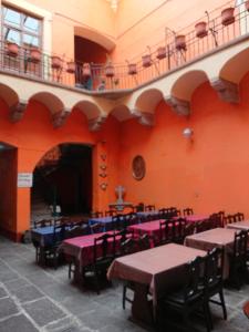 a room with tables and chairs and a balcony at Suite Vintage in Puebla