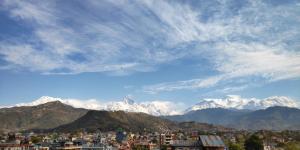 uma vista para uma cidade com montanhas cobertas de neve em Hotel Snow Peak em Pokhara