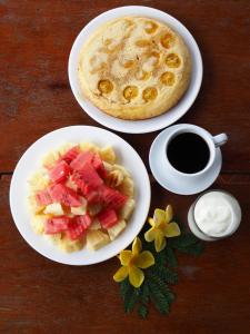 two plates of food with fruit and a cup of coffee at Nakai Resort in Ban Nakay Nua