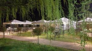 un jardín con mesas y tiendas de campaña por la noche en Locanda Corte Arcangeli, en Ferrara
