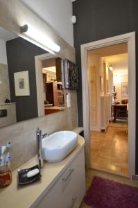 a bathroom with a sink and a mirror and a hallway at Art Styles Boutique Apartment Szentendre in Szentendre