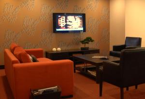 a living room with orange furniture and a tv on the wall at Silivri Park Hotel in Silivri