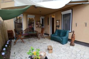 a patio with a couch and a table and a chair at Art Styles Boutique Apartment Szentendre in Szentendre