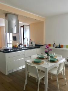 a kitchen with a white table and chairs and a kitchen with a counter at CASA MADDALENA in Lierna