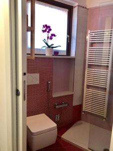 a bathroom with a toilet and a window with a plant at CASA MADDALENA in Lierna