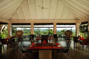 a dining room with tables and chairs and windows at Kahanda Kanda in Koggala
