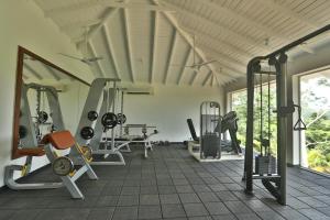 a gym with several treadmills and machines in a room at Kahanda Kanda in Koggala