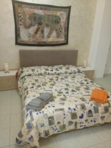 1 cama con edredón en un dormitorio en Mondello Beach Holyday, en Palermo
