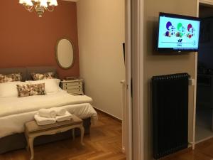 a bedroom with a bed and a tv on the wall at Athens-Plaka, Peter’s beautiful apartment in Temple of Zeus in Athens