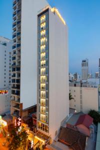 um edifício branco alto com luzes em cima em Agnes Nha Trang Hotel em Nha Trang