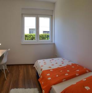 een slaapkamer met een bed en een raam bij Apartments Mobine in Metković