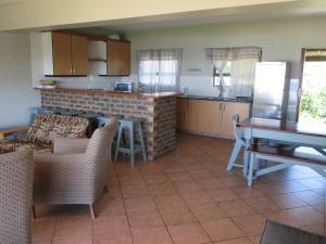 a kitchen and living room with a table and chairs at Wild Bay - Hole in the Wall Resort in Coffee Bay