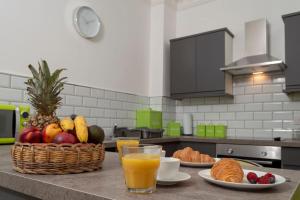 a table with a basket of fruit and a glass of orange juice at Tranquil Place in Dundee near Docks in Dundee