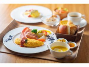 a table with plates of food and cups of coffee at WE Hotel Toya - Dusit Collection in Lake Toya