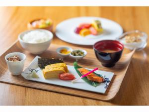 a tray with plates of food on a table at WE Hotel Toya - Dusit Collection in Lake Toya