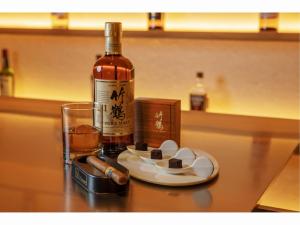 a bottle of wine and a plate of cookies and a glass at WE Hotel Toya - Dusit Collection in Lake Toya