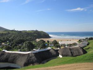 a view of a beach with huts and the ocean at Wild Bay - Hole in the Wall Resort in Coffee Bay