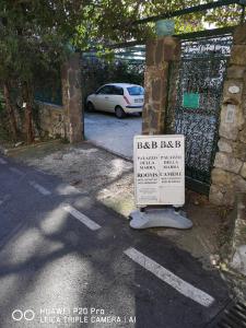 a sign in front of a gate with a car parked at Palazzo Della Marra in Ravello