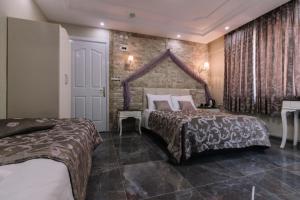 Un pat sau paturi într-o cameră la Melrose House Hotel