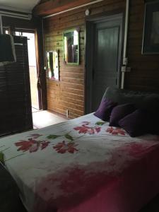 Un dormitorio con una cama con flores. en Le Chalet dAZAE, en La Rivière