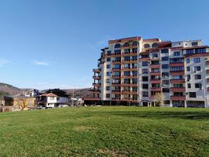 a large apartment building with a field in front of it at Апартамент "Скален венец" in Veliko Tŭrnovo