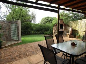 a patio with a table and chairs in a yard at Stone Hill in Magaliesburg