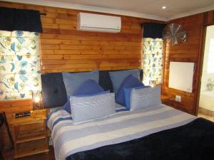 a bedroom with a large bed with blue pillows at Stone Hill in Magaliesburg