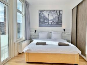 ein Schlafzimmer mit einem großen weißen Bett mit zwei Kissen in der Unterkunft Jordaan View in Amsterdam