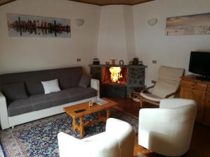 uma sala de estar com um sofá e uma lareira em Casa Maura em Aprica