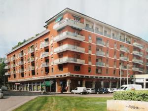 Un gran edificio con coches aparcados delante. en B&B Open Doors Verona, en Verona