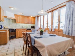 a kitchen with a table with a white table cloth at Chalet Guttannen EG - GriwaRent AG in Guttannen