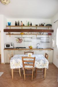 una cucina con tavolo e sedie in una stanza di Case La Filetta a Santa Teresa di Gallura