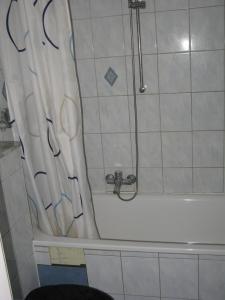 een badkamer met een douche en een bad met een douche bij Comfortable Homly Apartment in Offenbach
