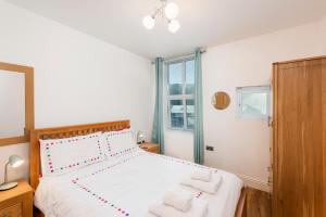 a bedroom with a large bed with two white towels at 10 At The Beach, Torcross in Beesands