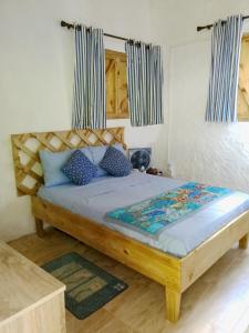 1 dormitorio con cama de madera y almohadas azules en Coco Bay Villa, en Baie Sainte Anne