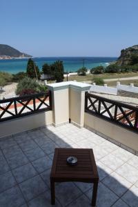 un patio con mesa y vistas al océano en Pleoussa Studio and Apartments, en Skopelos Town