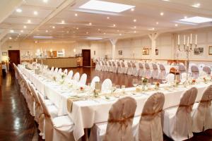 a large banquet hall with white tables and chairs at Landhotel Franck Garni in Brietlingen