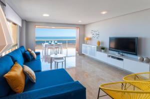 a living room with a blue couch and a television at Ag Bermudas Deluxe in Gandía