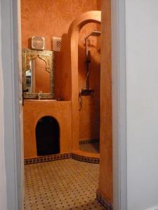 a bathroom with a shower and a sink and a mirror at Dar Mussarat in Essaouira