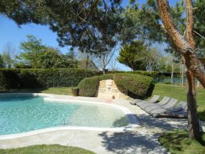 a swimming pool with lounge chairs in a yard at Camping Pré-Fixe in Cassagnabère-Tournas