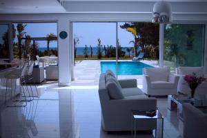 a living room with white furniture and a swimming pool at Katerina House in Perivolia