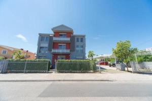 a building with a fence in front of a street at Hotel Piramida in Podgorica