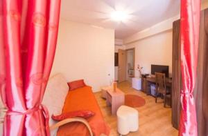sala de estar con cama con cortinas rojas en Hotel Piramida, en Podgorica