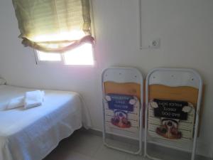 a room with a bed and two signs on the wall at Apartamentos Calypso in Punta Umbría