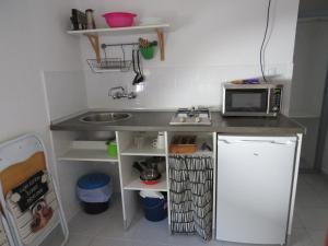 a small kitchen with a sink and a microwave at Apartamentos Calypso in Punta Umbría